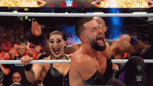 Wrestlers In A Ring With A Peacock Logo In The Background GIF