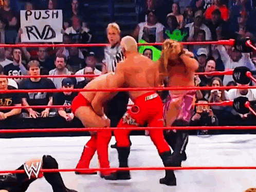 Wrestlers In A Ring With A Sign That Says " Push Rvd " GIF
