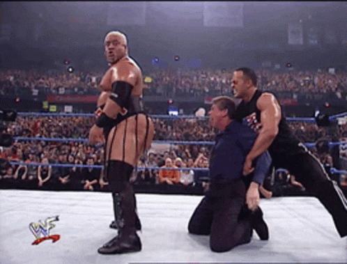 Wrestlers In A Wrestling Ring With A W Logo On The Bottom Right GIF