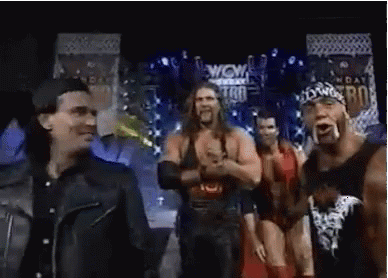 Wrestlers Standing on Stage in Front of Wow Sign