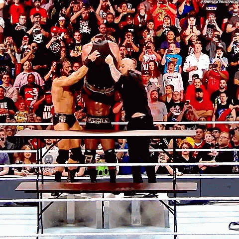 Wrestlers Standing On Table As Crowd Watches GIF
