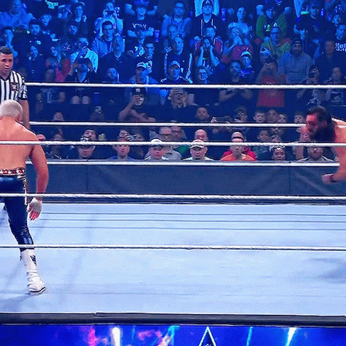 Wrestling Ring With Referee And Wrestler Holding Smackdown Belt GIF