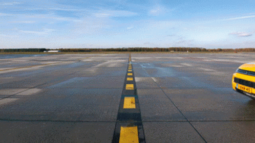 Yellow Car on Runway with Black and Yellow Stripe