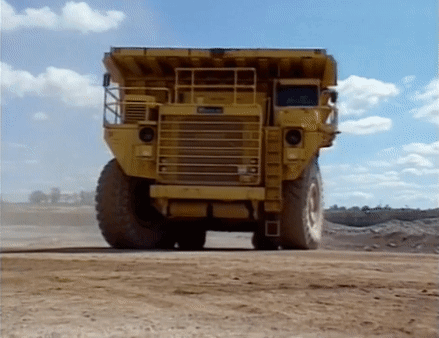 Yellow Dump Truck On Dirt Road GIF