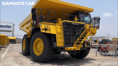 Yellow Dump Truck Parked In Front Of Building Saying Matsu GIF