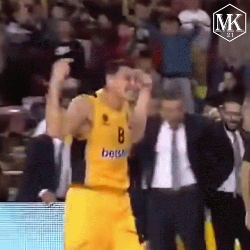 Yellow Jersey Man Raising Hands in Crowd