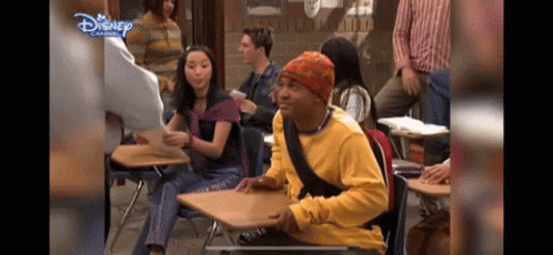 Yellow Shirt Man At Desk In Disney Classroom GIF
