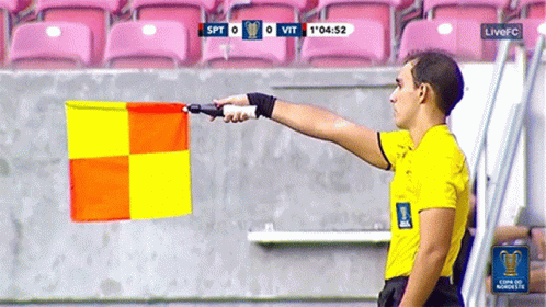 Yellow Shirt Man Holding Yellow Red Flag at Live FC Scoreboard