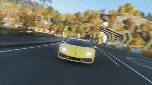 Yellow Sports Car Driving Down Road