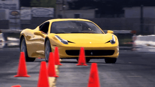 Yellow Sports Car Driving Through Red Cones