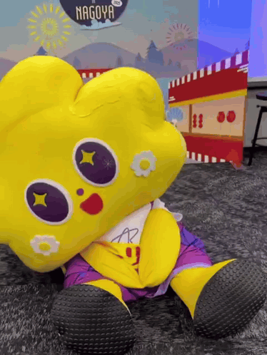 Yellow Stuffed Animal In Front Of Nagoya Sign GIF