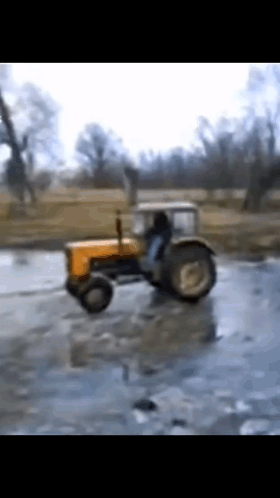 Yellow Tractor Driving Through Frozen Field
