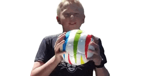 Young Boy Blowing Up Colorful Beach Ball