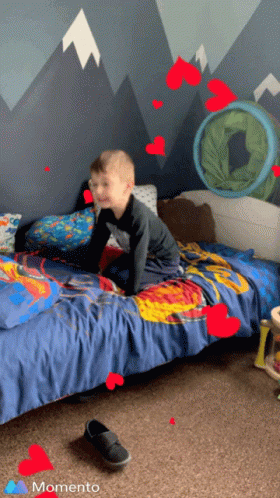 Young Boy Crawling On Bed With Hearts And Momento GIF