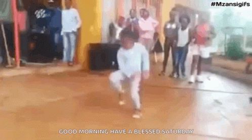 Young Boy Dancing With Group Behind Him