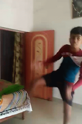 Young Boy Doing Handstand by Red Sign