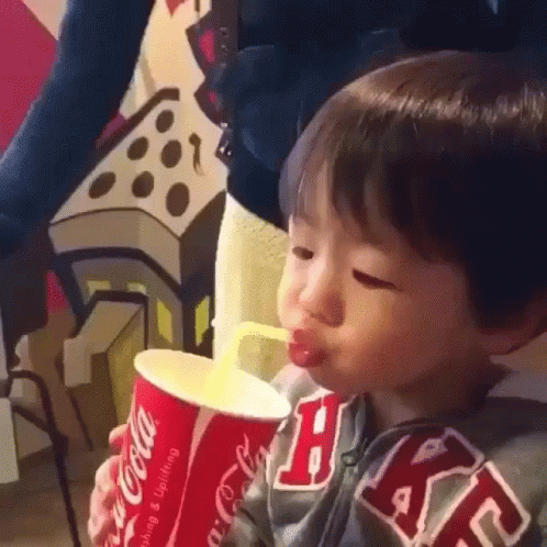 Young Boy Drinking From Coca-Cola Cup