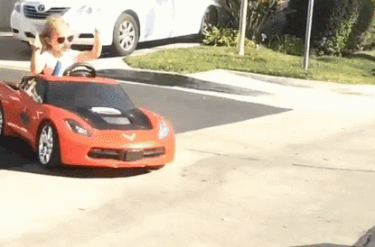 Young Boy Driving Red Toy Car