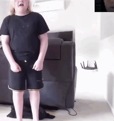 Young Boy in Black Shirt and Shorts by Couch