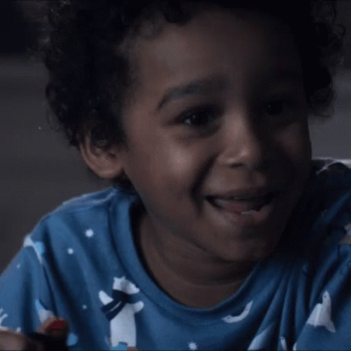 Young Boy in Blue Shirt Laughing Lollipop