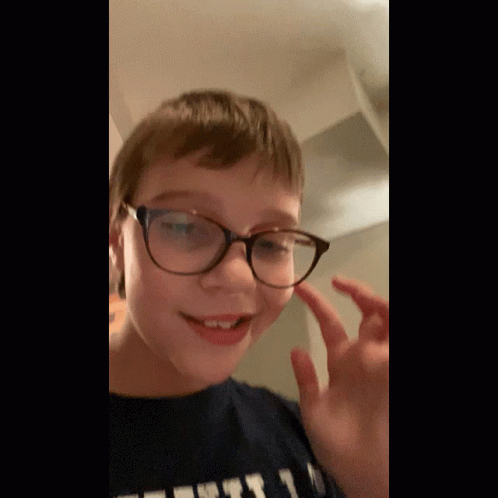 Young Boy in Glasses and T-Shirt Saying First