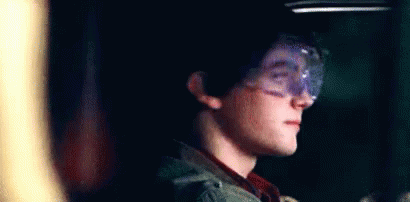 Young Boy In Goggles Smiling In Dark Room GIF
