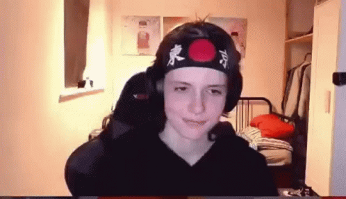 Young Boy in Headband With Red Circle Sitting at Computer