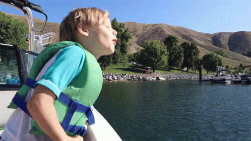 Young Boy In Life Jacket On Boat GIF