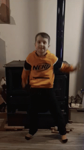 Young Boy in Nerf Sweatshirt Dancing in Front of Fireplace