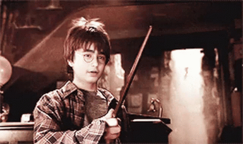 Young Boy in Plaid Shirt Holding Wand in Dark Room
