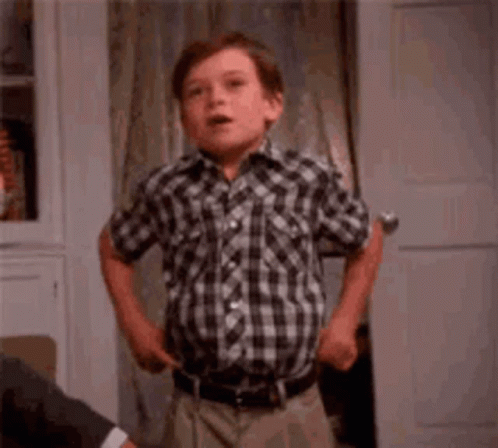 Young Boy in Plaid Shirt Making Funny Face at Door