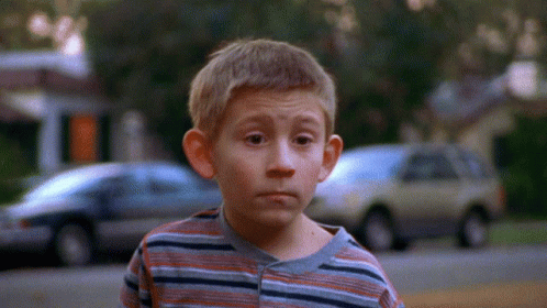 Young Boy in Striped Shirt With Cars Background