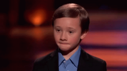 Young Boy In Suit And Blue Shirt On Stage GIF