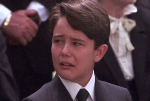 Young Boy In Suit Crying In Crowd GIF
