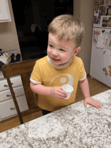 Young Boy In Yellow Shirt Holding Cup GIF