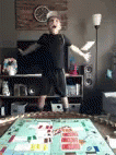 Young Boy Looking At Falling Monopoly Money GIF