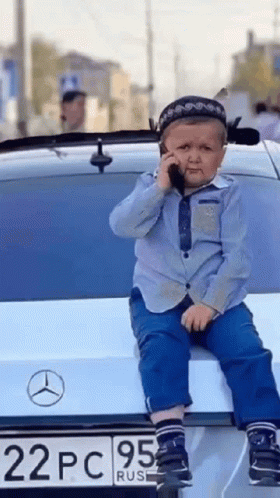 Young Boy on Car Back Talking on Phone
