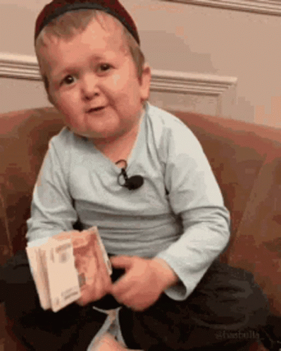 Young Boy On Couch Holding Money GIF