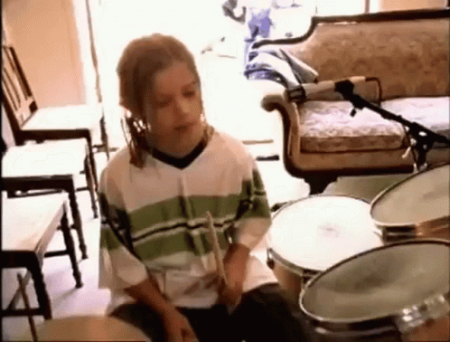 Young Boy Playing Drums in Living Room With Microphone