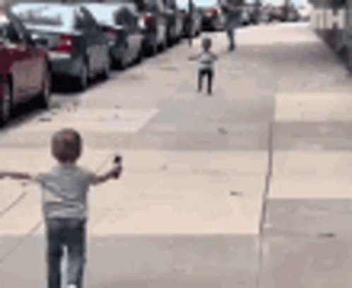 Young Boy Riding Scooter Arms Outstretched GIF