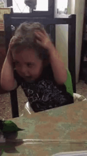Young Boy Scratching Head in High Chair