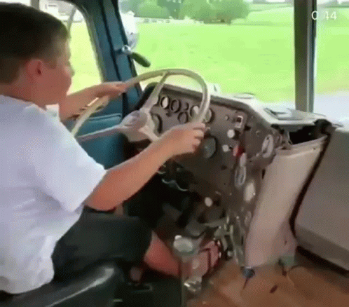 Young Boy Sitting in Driver Seat of Bus