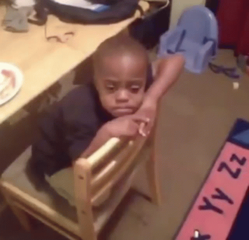 Young Boy Sitting in Wooden Chair Head Resting