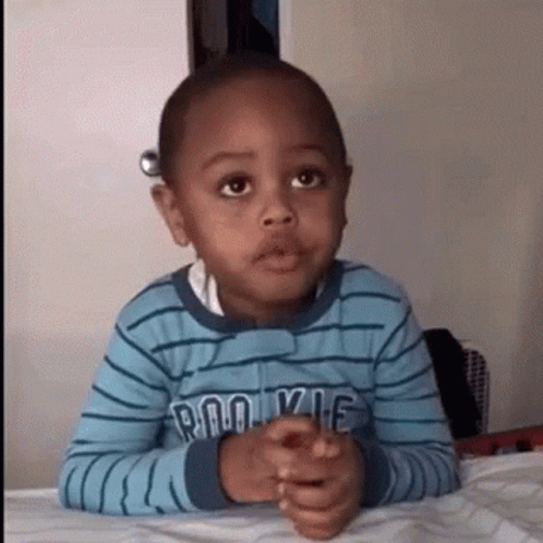 Young Boy Sitting with Hands Folded