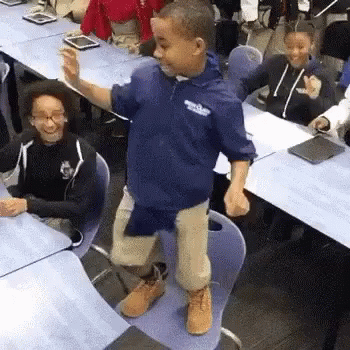 Young Boy Standing on Chair in Classroom