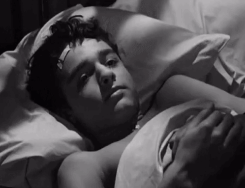 Young Boy With Bandage on Forehead Lying in Bed