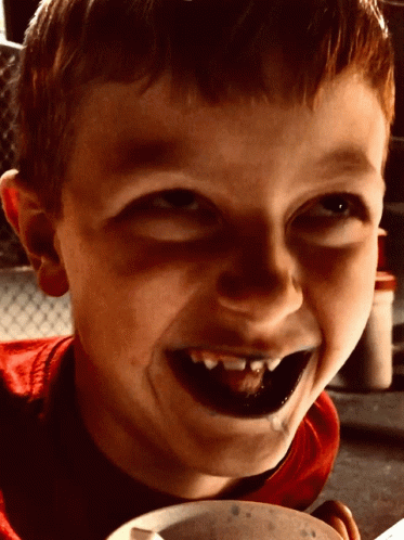 Young Boy With Black Teeth Smiling Holding Bowl of Food