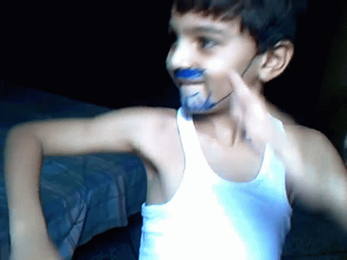 Young Boy With Blue Paint on Face and White Tank Top