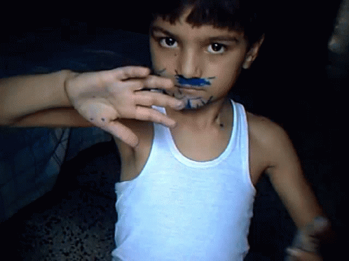 Young Boy With Blue Paint on Face in Tank Top