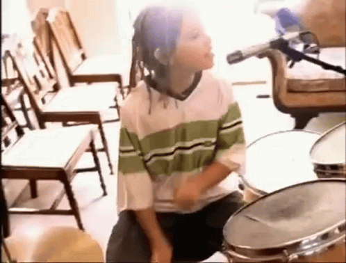 Young Boy With Dreadlocks Playing Drums